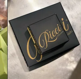 The signature matte-black Ricci Chocolates gift box with the gold foil-stamped script wordmark